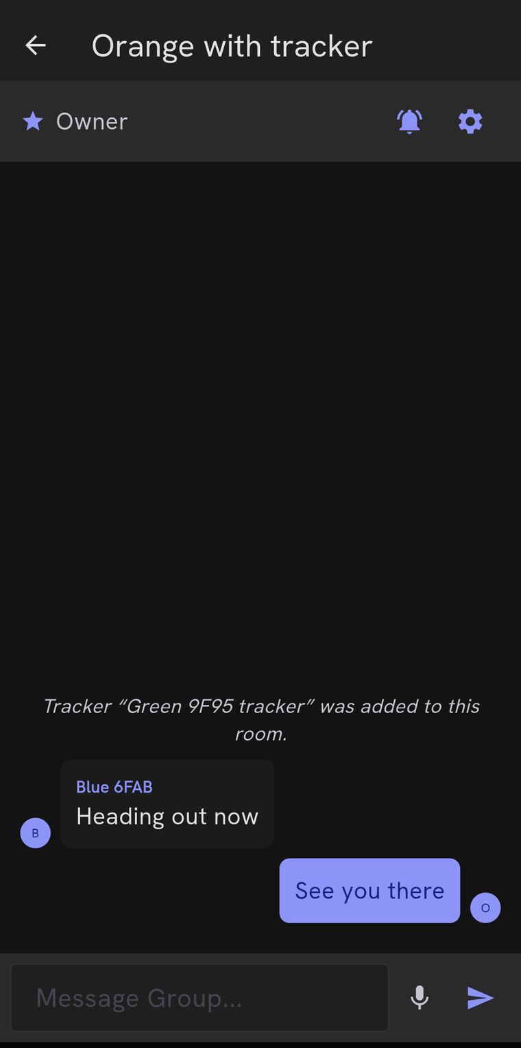 A room called Orange with tracker, marked Owner, with a mute bell and a settings gear. A system line says a tracker was added to the room, followed by an incoming message reading Heading out now and an outgoing reply reading See you there. The compose row at the bottom has a microphone and a send button.